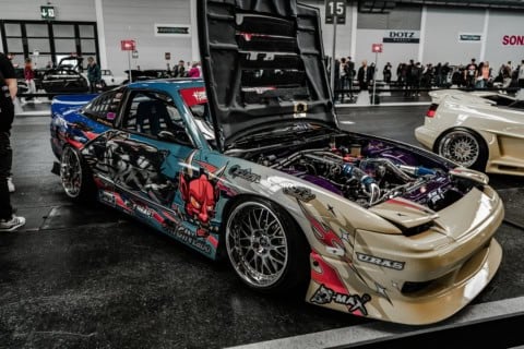 Mașină de curse personalizată cu design agresiv și motor puternic, expusă la eveniment auto de perfo.