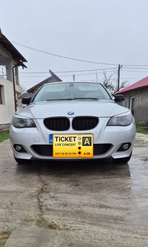 Mașină BMW E60 2.0D, model din 2003-2010, în stare bună, parcat pe drum asfaltat.
